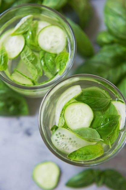 Cocktail di verdure fresche estive verdi Mocktail con foglie di basilico e cetriolo Bevanda fresca verde su sfondo grigio