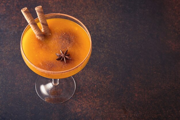 Cocktail di zucca con cannella, succo d'arancia e cacao in tazze di vetro. Bevanda autunnale di zucca per Halloween o il Ringraziamento.