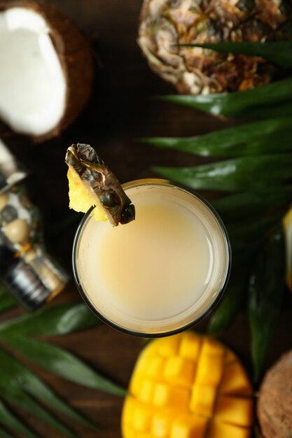 Cocktail e ingredienti di pina colada su fondo di legno.