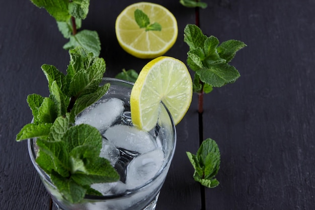 Cocktail estivi di limonata salutare di acqua infusa di agrumi o mojito con lime, limone, arancia, ghiaccio e menta Limonata rinfrescante fatta in casa con fette di agrumi Primo piano