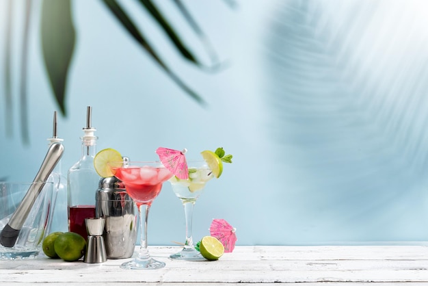 Cocktail estivi freschi con lime alla fragola e cubetti di ghiaccio su sfondo blu con spazio per la copia