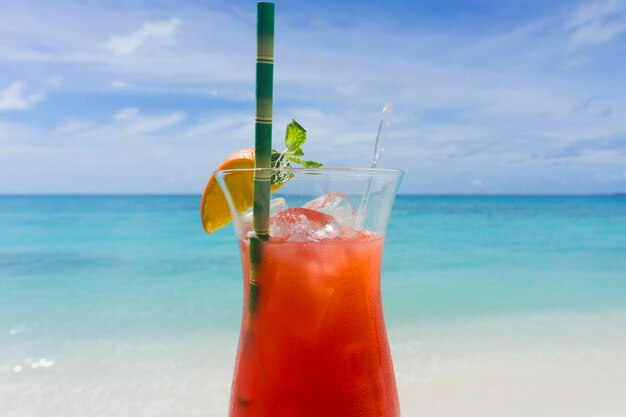 Cocktail estivo contro il mare tropicale e lo sfondo del cielo