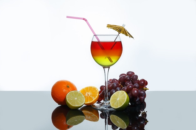 Cocktail estivo luminoso in un bicchiere e frutta