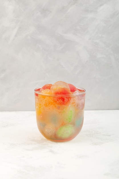 Cocktail estivo rinfrescante con ghiaccio di frutta colorata Bevanda gassata arcobaleno Bibita analcolica multicolore