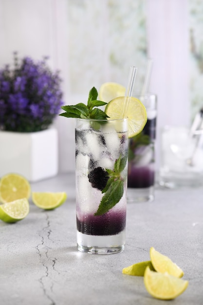 Cocktail estivo rinfrescante Mojito alla mora con ghiaccio, menta fresca e lime