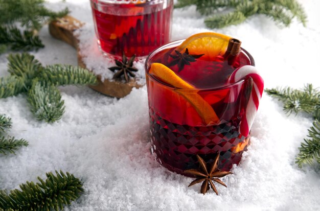 Cocktail festosamente stilizzato sulla neve e rami di abete rosso sparsi