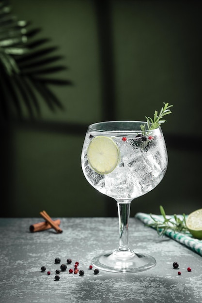 Cocktail gin tonic e ombre accanto alla finestra su sfondo di cemento scuro Formato verticale