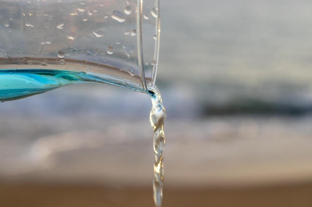 cocktail laguna blu contro il mare o l'acqua della piscina che scorre dal vetro. anello gonfiabile forma unicorno