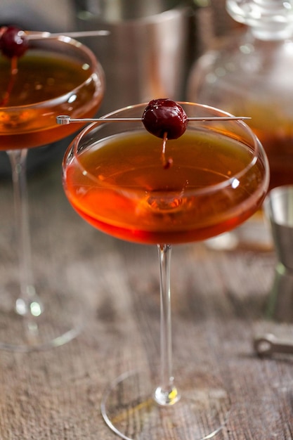 Cocktail Manhattan guarnito con ciliegie sotto spirito.