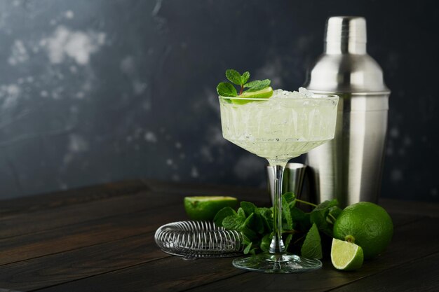 Cocktail Margarita con tequila al lime, menta e ghiaccio su un tavolo scuro con un fantastico spazio di copia retroilluminato Margarita classico o Daiquiry Cocktail Bar card o concetto di banco Messa a fuoco selettiva o morbida