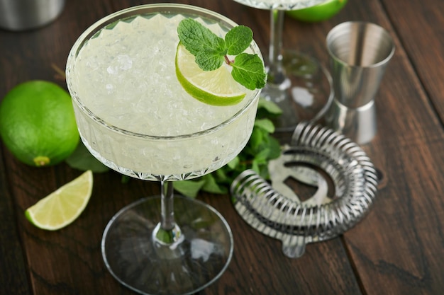 Cocktail Margarita con tequila al lime, menta e ghiaccio su un tavolo scuro con un fantastico spazio di copia retroilluminato Margarita classico o Daiquiry Cocktail Bar card o concetto di banco Messa a fuoco selettiva o morbida