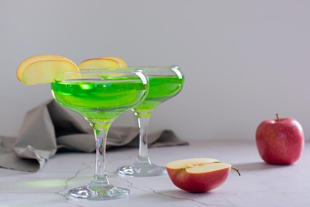 Cocktail martini alla mela verde fatto in casa con pezzi di mela in bicchieri