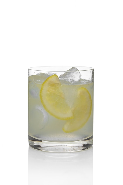 Cocktail martini e tonico con limone e ghiaccio isolato su bianco.