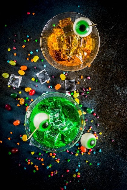 cocktail martini verde e arancione con cubetti di ghiaccio e decorazioni con occhi marshmallow