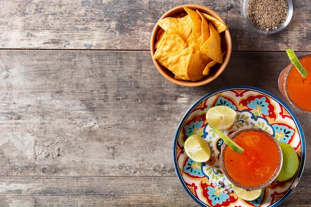 Cocktail michelada fatto in casa con succo di lime alla birra, salsa calda, bordo salato e succo di pomodoro