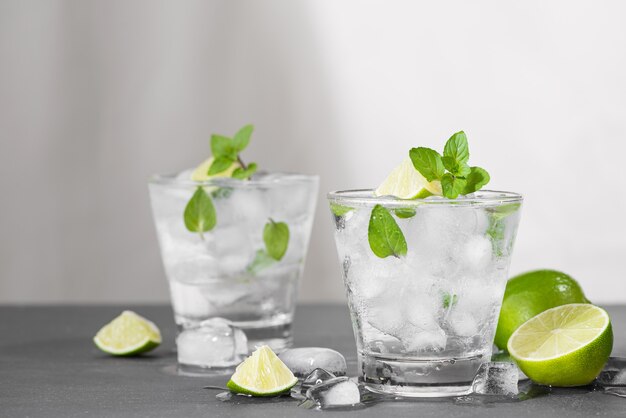 Cocktail Mojito con lime e menta in vetro su uno sfondo di pietra grigia