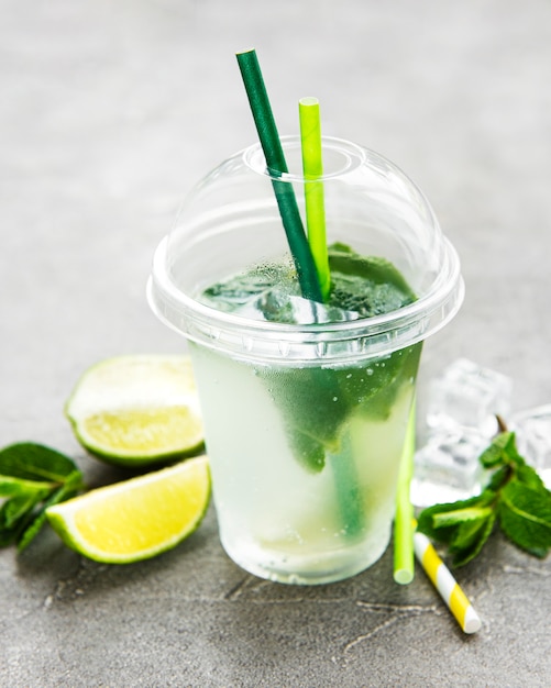 Cocktail Mojito con lime e menta su sfondo grigio cemento