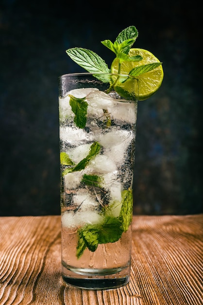 Cocktail Mojito decorato con limone e menta piperita su un tavolo di legno Senza paglia