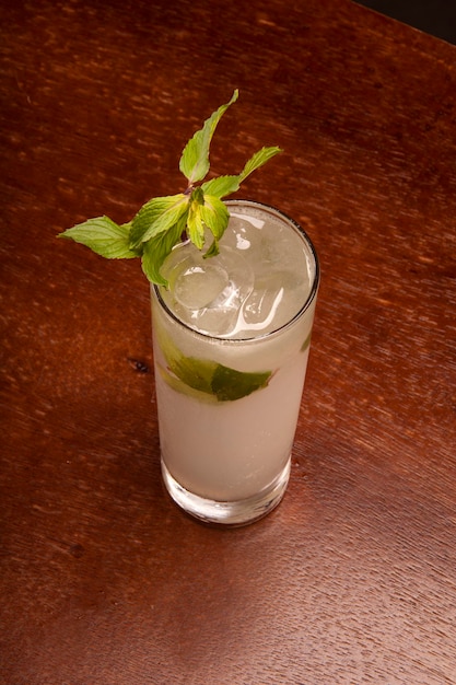 Cocktail Mojito in long drink con vista dall'alto di menta e ghiaccio sul tavolo di legno