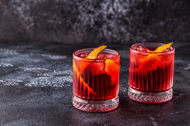 Cocktail Negroni con buccia d'arancia e ghiaccio, fuoco selettivo.