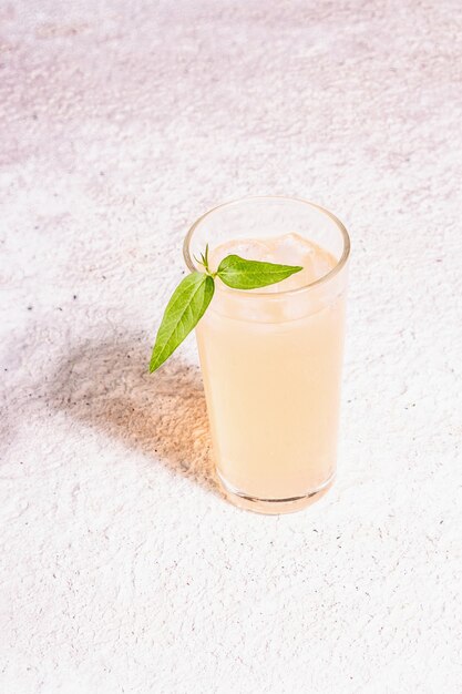 Cocktail rinfrescante estivo. Bevanda dolce fredda, luce dura moderna, ombra scura. Sfondo di mastice, posto per il testo