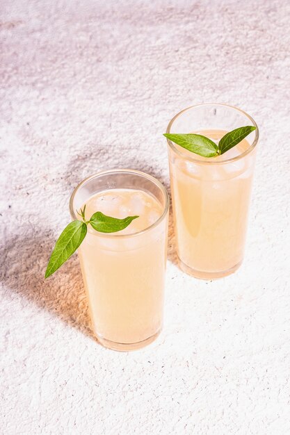 Cocktail rinfrescante estivo. Bevanda dolce fredda, luce dura moderna, ombra scura. Sfondo di mastice, posto per il testo