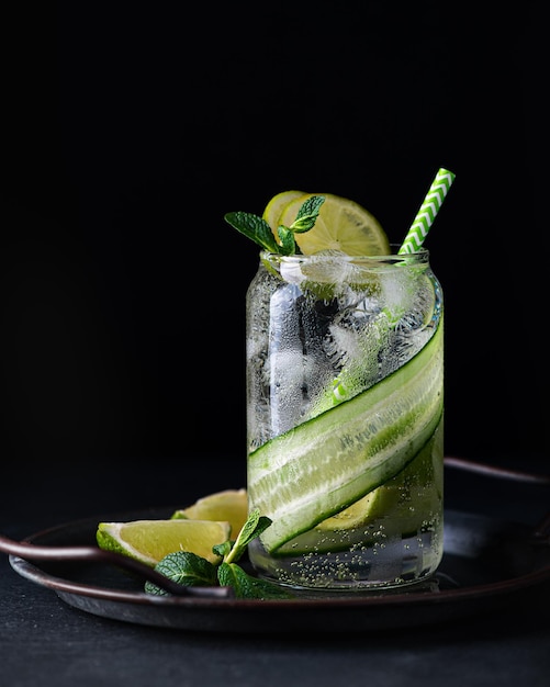 cocktail rinfrescante estivo con lime e cetriolo, messa a fuoco selettiva, foto scura