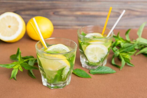 Cocktail rinfrescante estivo Mojito con ghiaccio e menta Cocktail mojito con lime, limone e menta in un bicchiere alto con un bastoncino