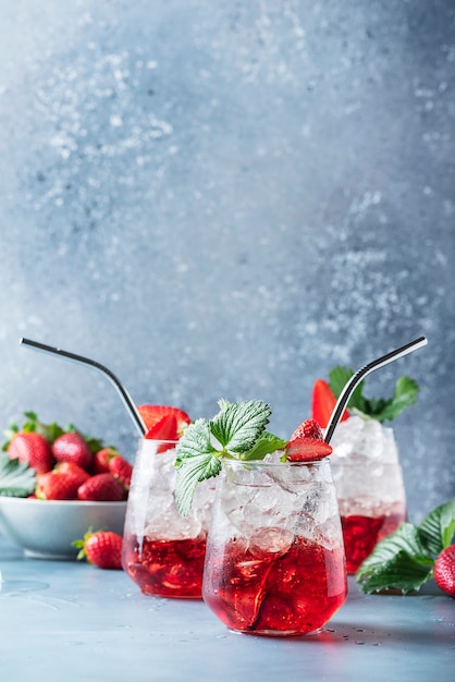 Cocktail rosso con ghiaccio e la fragola fresca