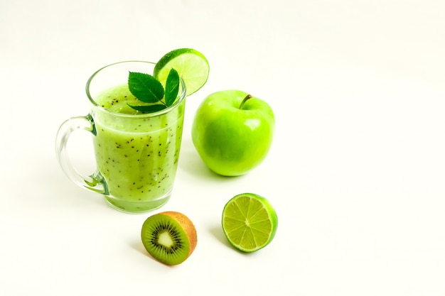 Cocktail sano verde del kiwi, della mela verde, della calce e della menta isolati sulla vista bianca del fondo di un truffatore