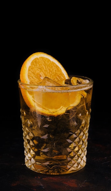 Cocktail vecchio stile con ghiaccio e fetta d'arancia