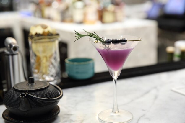 Cocktail viola su sfondo bar