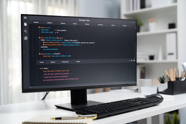 Codifica del programma visualizzata sul monitor del computer in piedi sulla scrivania di lavoro Postulato