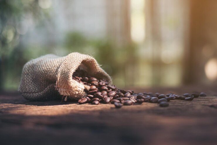 coffee beans in a burlap bag on a wooden background