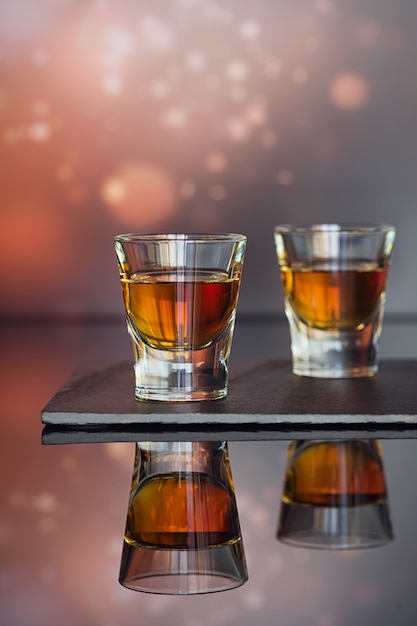 Cognac o liquore, chicchi di caffè e spezie su un tavolo di vetro