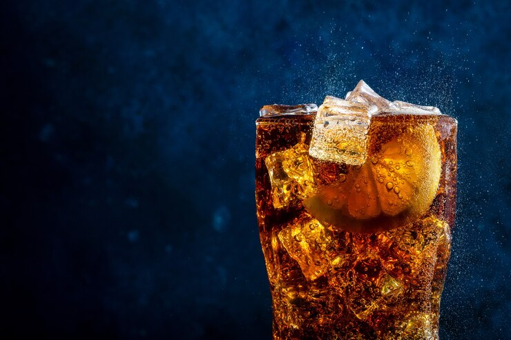 Cola fredda con limone e ghiaccio su sfondo blu