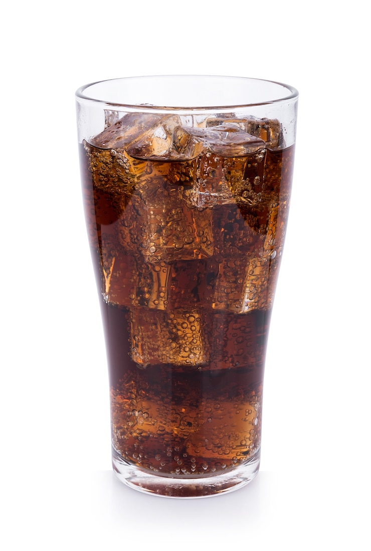 Cola in vetro con cubetti di ghiaccio sulla superficie bianca