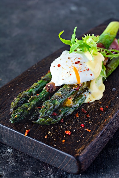 Colazione a base di asparagi al forno in spezie con pancetta, uovo in camicia