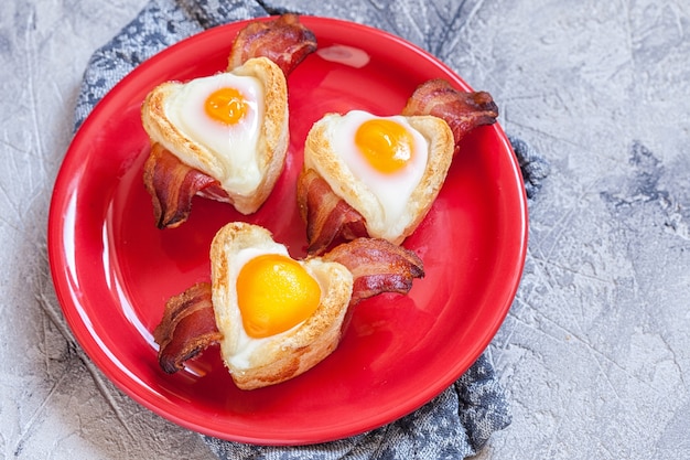 Colazione a base di uova al forno con pancetta e pane tostato a forma di cuore per San Valentino