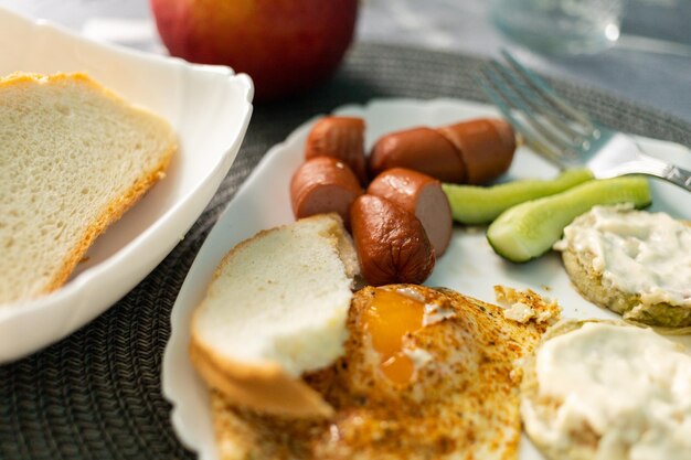 Colazione a base di uova e salsicce con pane