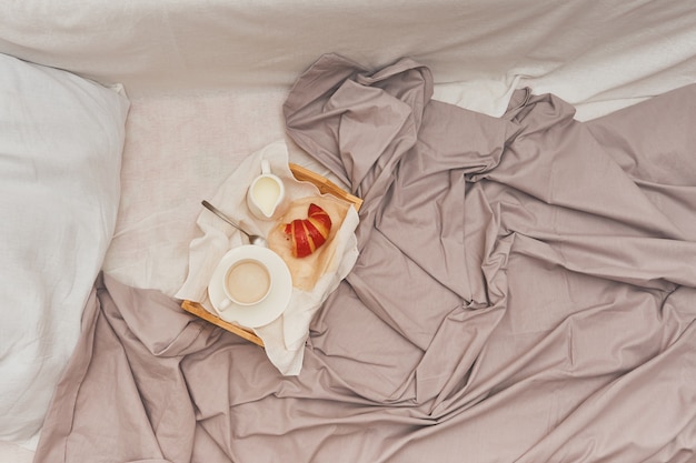 Colazione a letto, caffè con panna, cornetti in marmellata