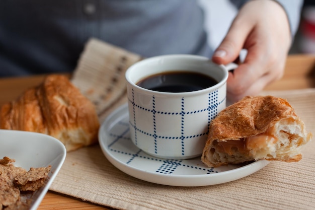 Colazione a letto che serve vassoio con croissant e tazza di caffè in hotel