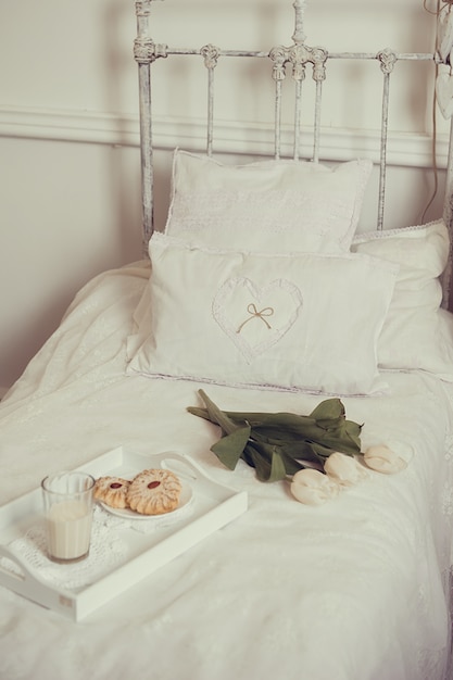 Colazione a letto con fiori, latte e biscotti