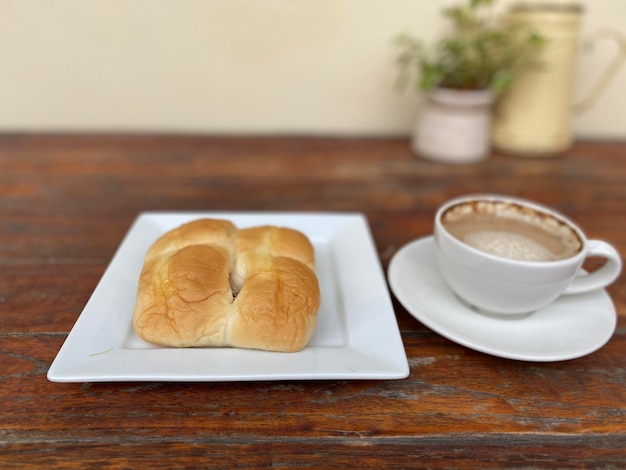 colazione al mattino con caffè e pane sul tavolo di legno.