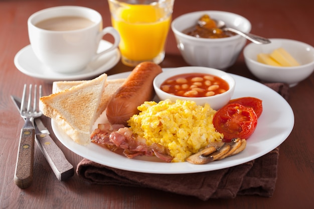 Colazione all'inglese con uova strapazzate, pancetta, salsiccia, fagioli e pomodoro