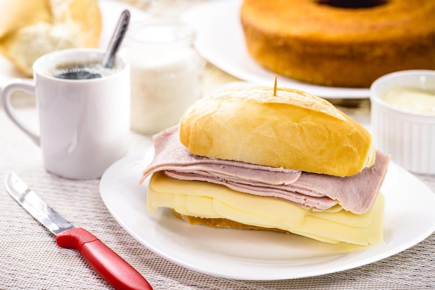 Colazione brasiliana pane francese al sale con mozzarella e prosciutto servito con caffè caldo e torta di farina di mais