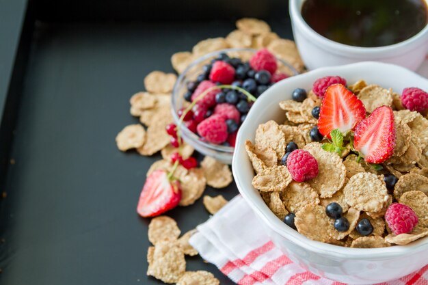 Colazione - cereali e frutti di bosco in una ciotola bianca