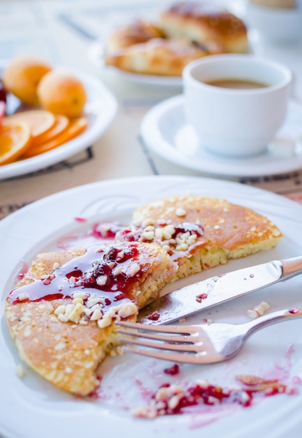 Colazione comprensiva di frittelle con marmellata di lamponi