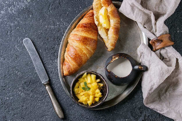 Colazione con croissant e frutta di mango
