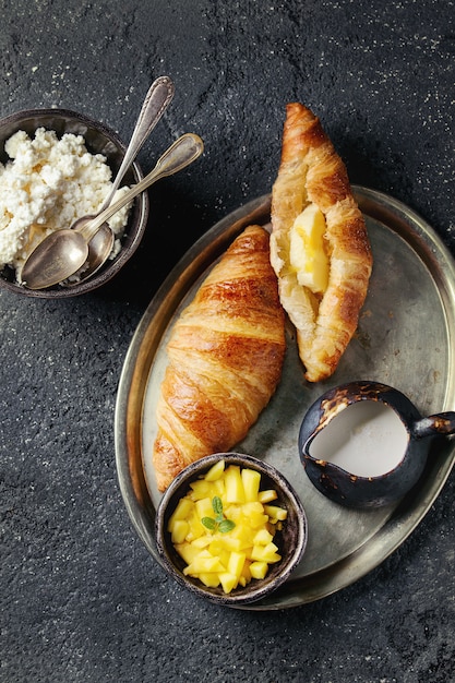 Colazione con croissant e frutta di mango